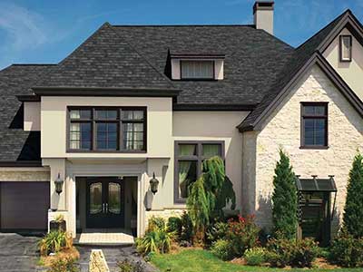 Front view of a beige home with black GAF shingles on its roof